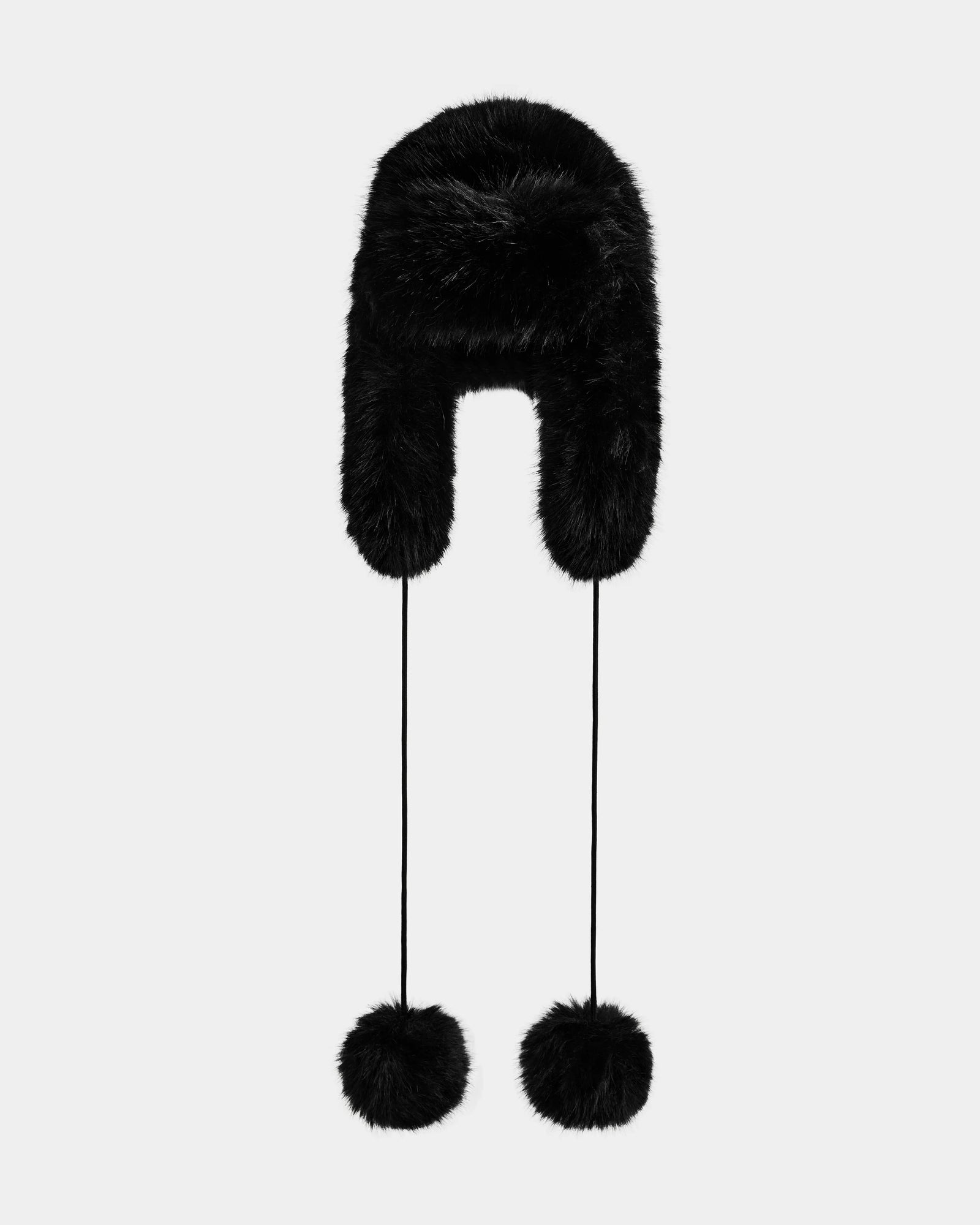The Rudsak DEMI - L425539 Black women’s faux-fur aviator hat features long ear flaps and two fluffy pom-poms on strings, shown against a plain light background—the perfect chic, cozy winter accessory.