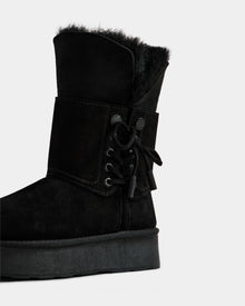 The Rudsak INESA - L225026 Black is a women's suede platform boot with a wool lining, thick sole, and ankle lace-up detail, shown on a plain white background.