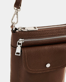Close-up of the Rudsak LILA - L325513 Mocha women’s crossbody bag, featuring silver hardware, a front snap pocket, adjustable strap clip, and textured pebbled leather.