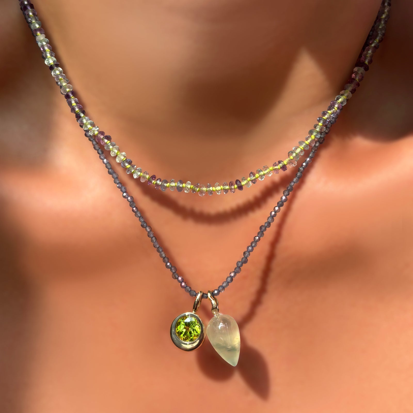 Faceted Fluorite on Neon necklace layered over an iolite slim gemstone necklace with round molten charm with peridot, and prehnite drop charm