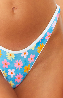 Close-up of the high-cut leg line of blue floral bikini bottoms with pink, yellow, and orange flowers and white piping