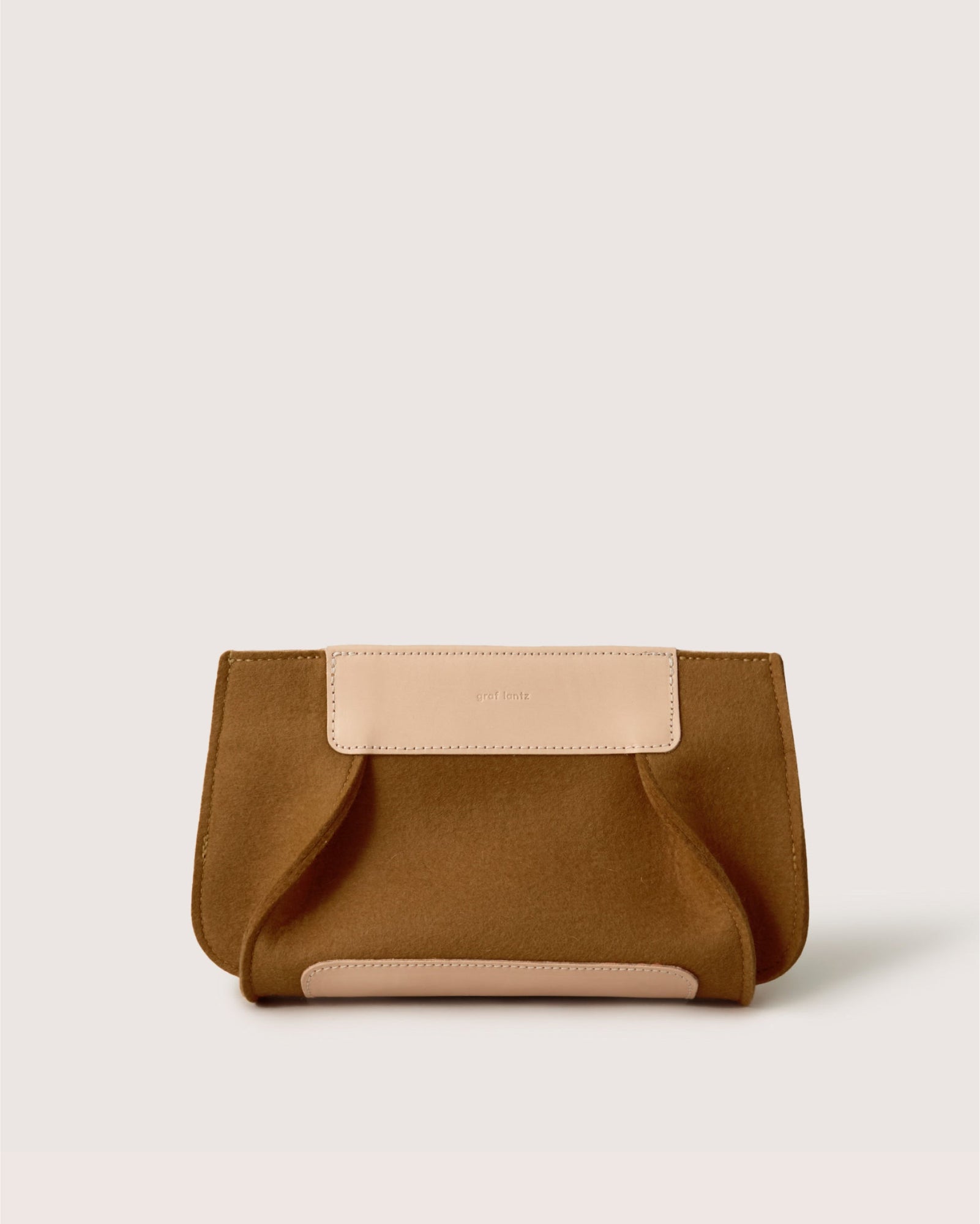 The Graf Lantz brown clutch purse, sustainably crafted from Merino wool with light beige leather accents, rests elegantly on a plain white background.