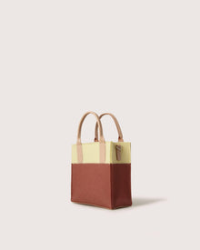 The Graf Lantz mini tote handbag features a chic two-tone design with beige dual handles, a light yellow top half, and a brown bottom half, set against a plain white background.