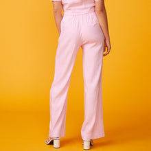 Back view of model wearing the linen pleated pants in bubble gum. 