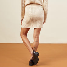 Back view of model wearing the sweater mini skirt in off white.