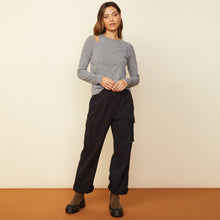 Front view of model wearing the asymmetric long sleeve top in granite.