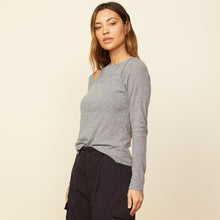 Side view of model wearing the asymmetric long sleeve top in granite.