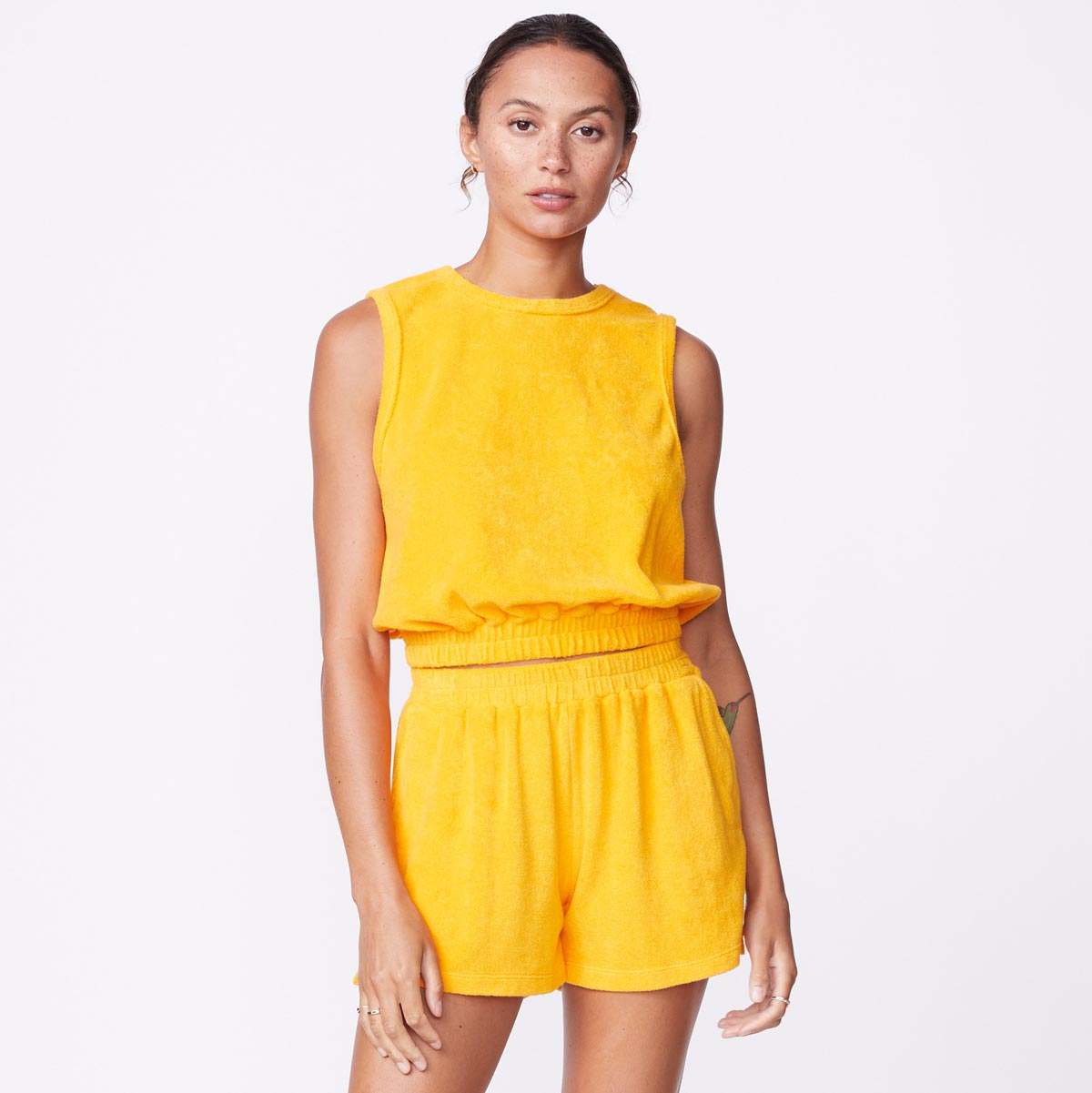 Front view of model wearing the terry cloth tank in marigold.