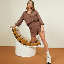 Front view of model wearing the poplin shorts in dusty cocoa.