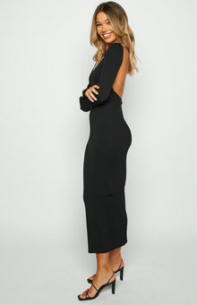 Side view of a black ribbed knit maxi dress with long sleeves and an open back detail
