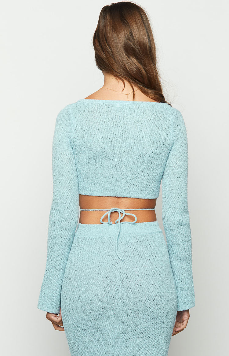 Close-up of the light blue knit top with a square neckline, large bust cutout, and wrap-around tie detail