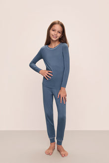 Model wears Kids TENCEL Modal Unisex Long PJ Set in Coastal Blue/Ice Blue.