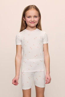 Model is wearing the Kids Printed TENCEL Modal Unisex Short PJ Set in Summer Daisy/Pale Mauve