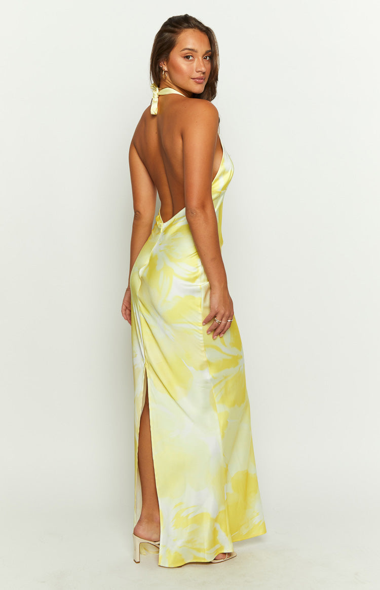 Side-front view of a yellow and white tie-dye maxi dress with a deep V-neck halter and a flowing skirt