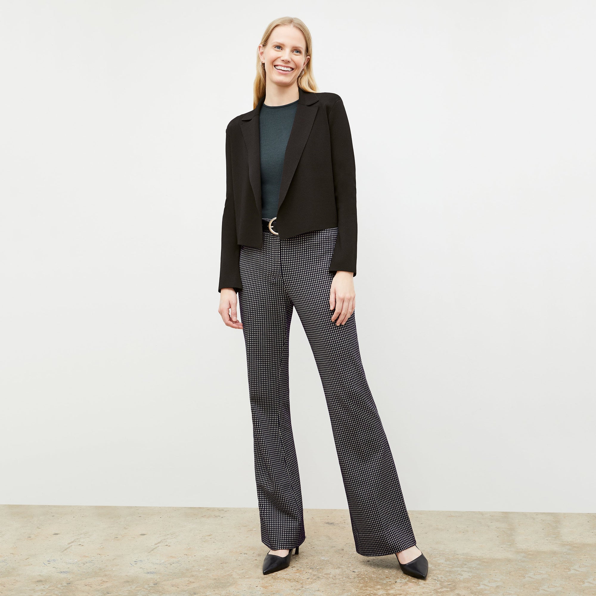 Front image of a woman wearing the horton pant in black and white houndstooth 