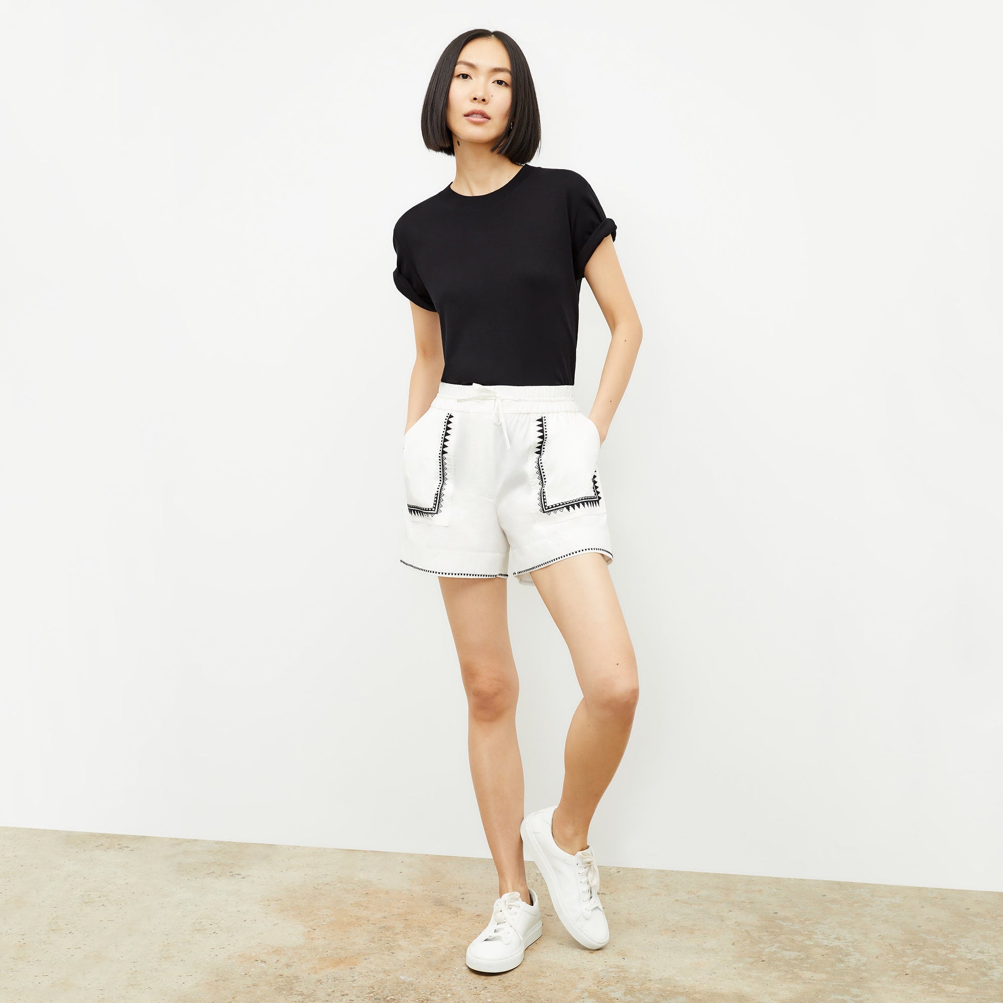 front image of a woman wearing the adina short in white