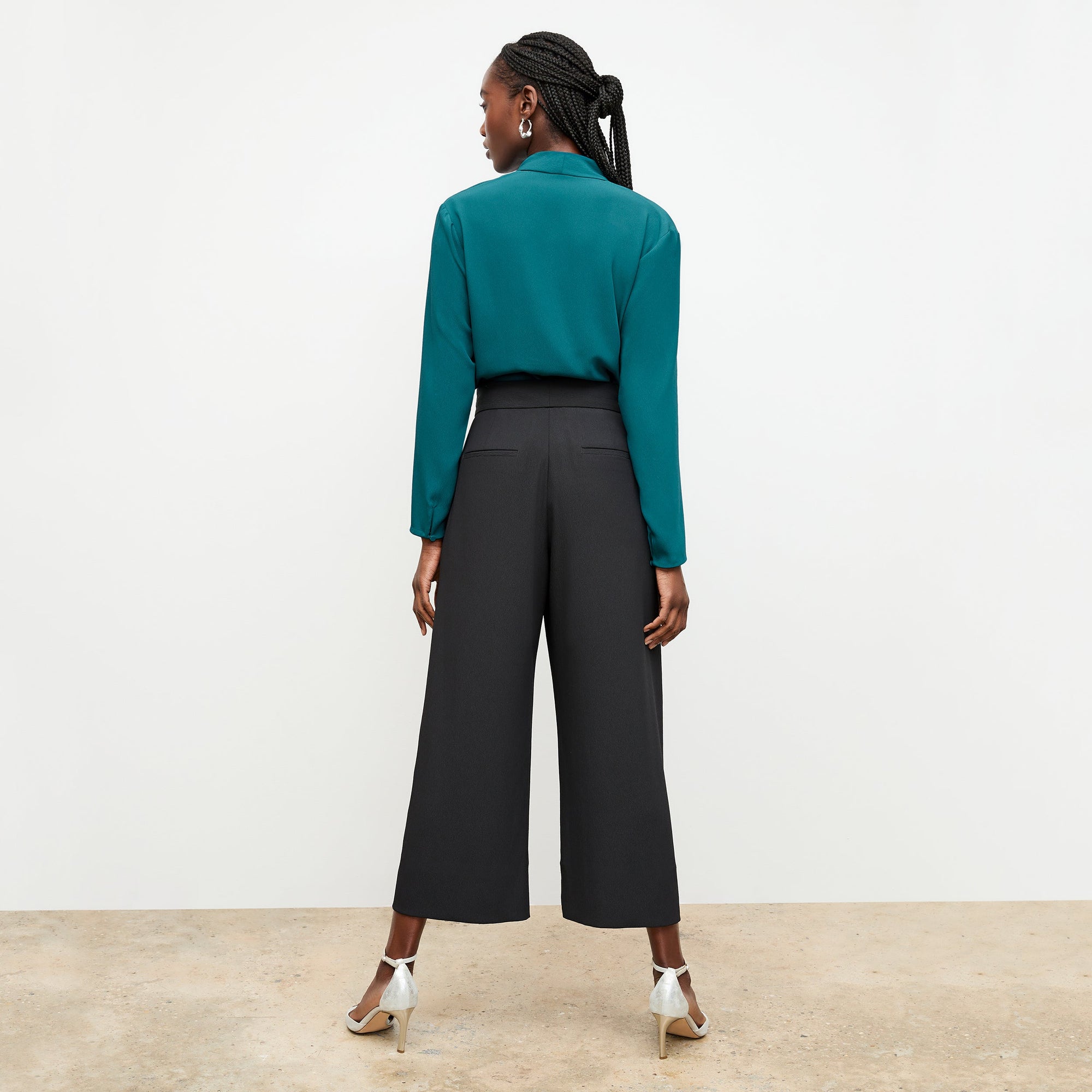 Back image of a woman standing wearing the Zhou culotte in black | Exclude