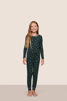 Model is wearing Kids Printed TENCEL Modal Unisex Long PJ Set  in Holiday Dogs Pine/Ivory