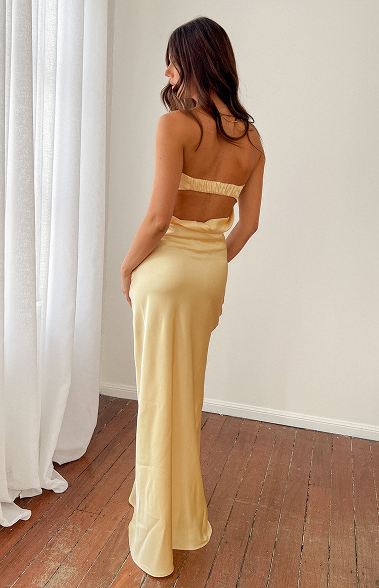 Rear view of a yellow strapless maxi dress with an elasticated back band and a lower back cutout