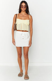 Front view of a white mini skirt with an elasticated drawstring waist and gold-tone toggles