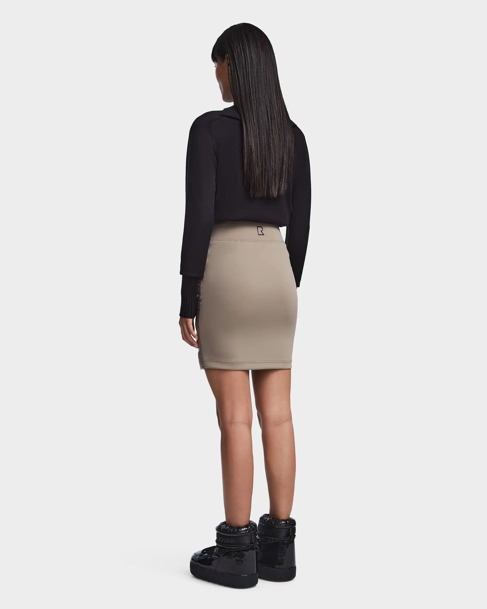 A woman wearing the MARZI - 8523528 Cement skirt by Rudsak paired with a black shirt.