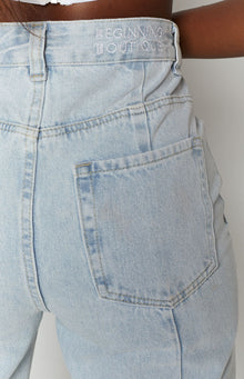 Light wash denim jeans with a patch back pocket and embroidered logo on the back waistband