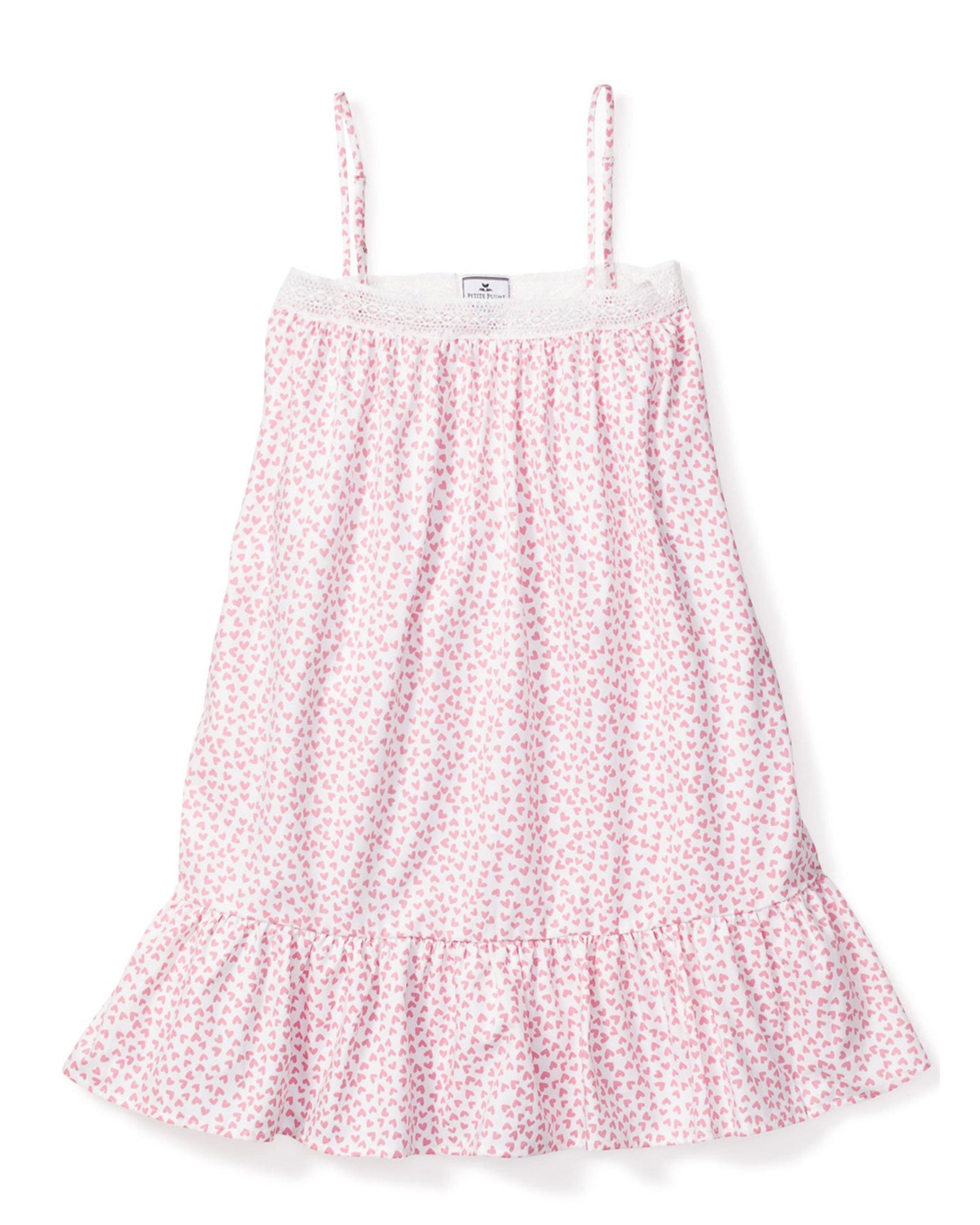The Girls Twill Lily Nightgown in Sweethearts by Petite Plume is a luxurious sleeveless, knee-length sleepwear piece. It features thin straps, a pink heart pattern on a white background, and is crafted from yarn-dyed cotton with a textured upper section and ruffled bottom hem.