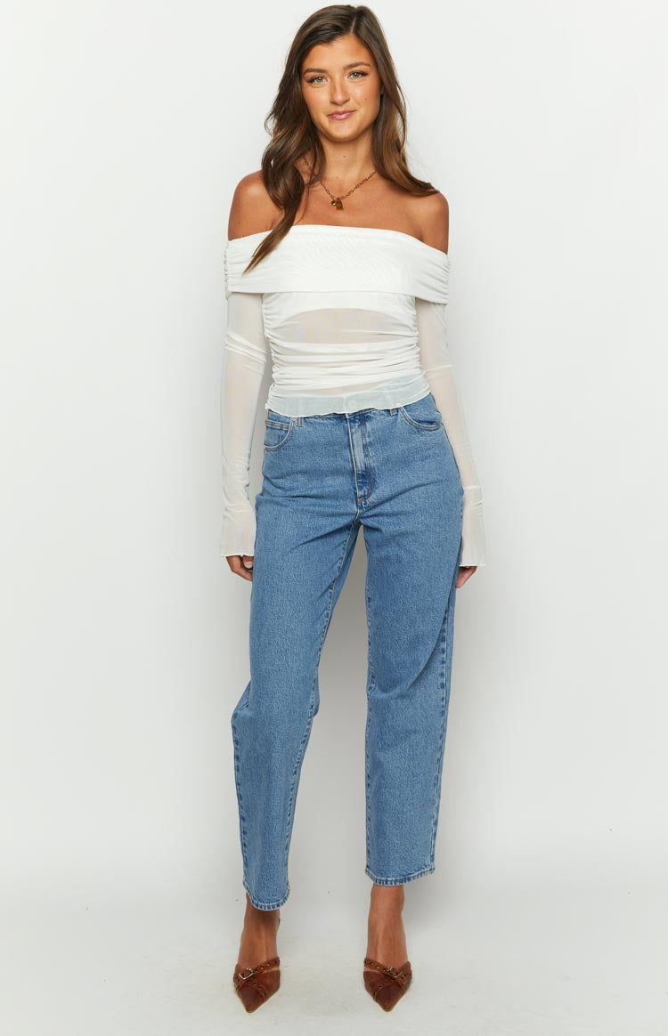 Front view of a white mesh off-shoulder top with a ruched bodice, sheer long sleeves, and lettuce hem
