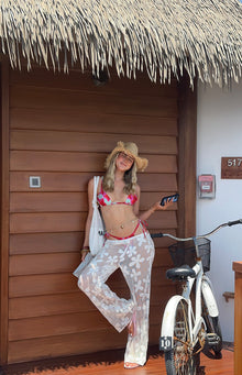 Front view of green floral tie-up bikini bottoms with red side ties