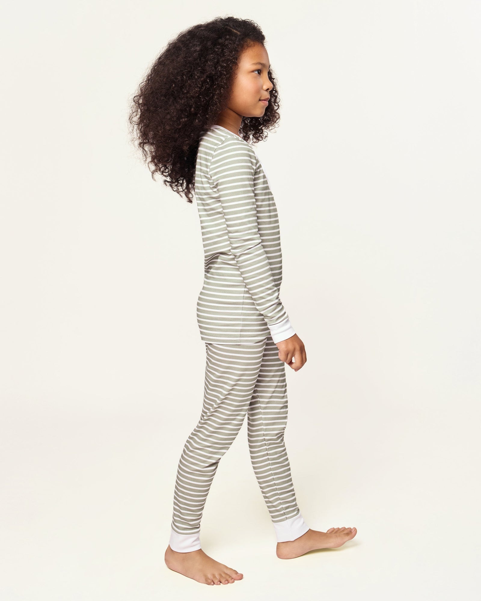 The Kid's Pima Snug Fit Pajama Set in Sage Stripe features green and white horizontal stripes, long sleeves, white cuffs at wrists and ankles, and a small button placket on the shirt. The set is displayed flat on a white background.