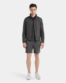 A young man faces forward, wearing the Rudsak RAGAB - 6124577 Grey men’s hybrid jacket with lightweight down insulation over a matching shirt and shorts, paired with white sneakers, against a plain white background.