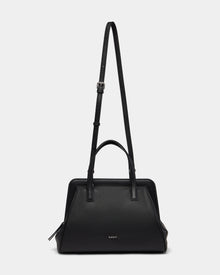 The Rudsak TAULLA - 8325002 Black is a womens pebble leather satchel with two short handles, a removable shoulder strap, spacious interior, structured design, and subtle front branding—shown on a plain white background.