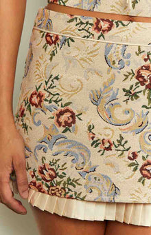 Close-up of the beige pleated trim detail at the hem of the tapestry skirt