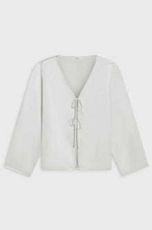 White blouse with a V-neck and long sleeves on a light gray background