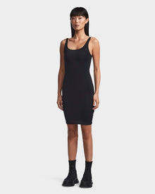 A woman with straight black hair wears the Rudsak MILEY - 8523034 BLACK sleeveless bodycon dress and black combat boots, standing against a plain white background.
