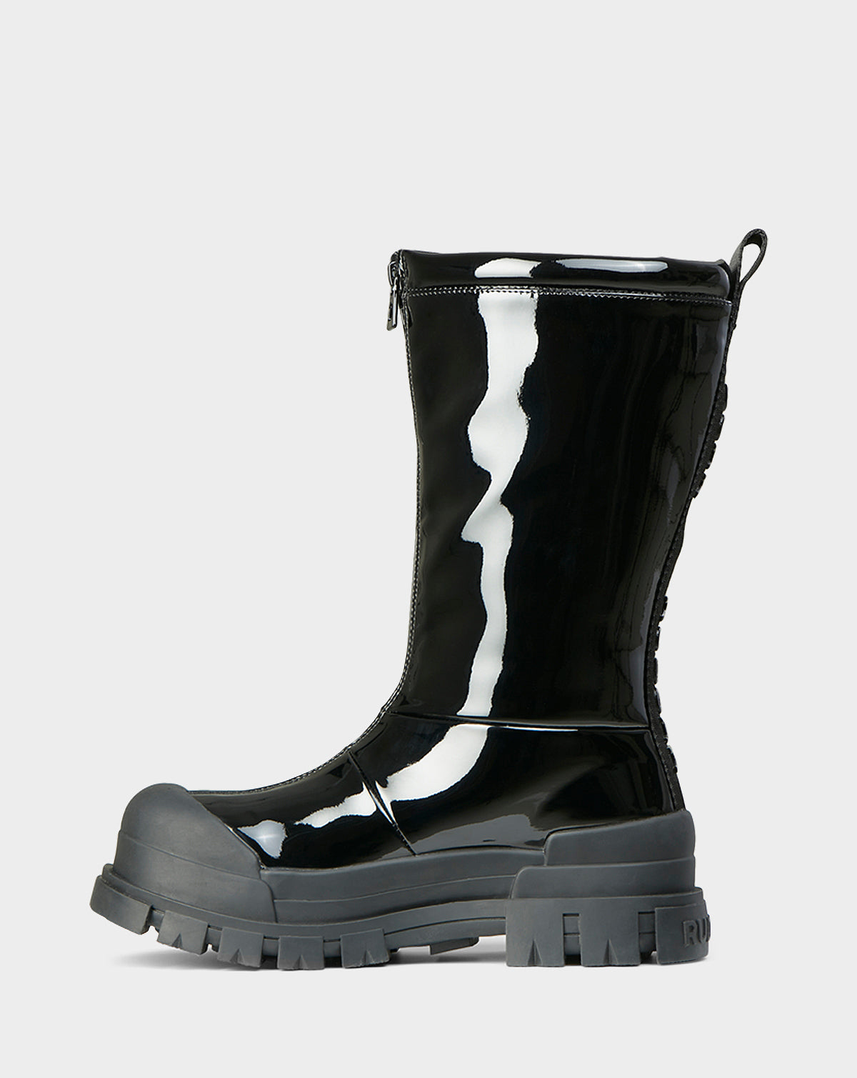 The KRISTAL HI - 8222510 BLACK by Rudsak is a black, mid-calf high-gloss winter boot with chunky grip soles, a thick gray rubber toe cap, side zipper, and back lacing detail, shown on a plain light background.