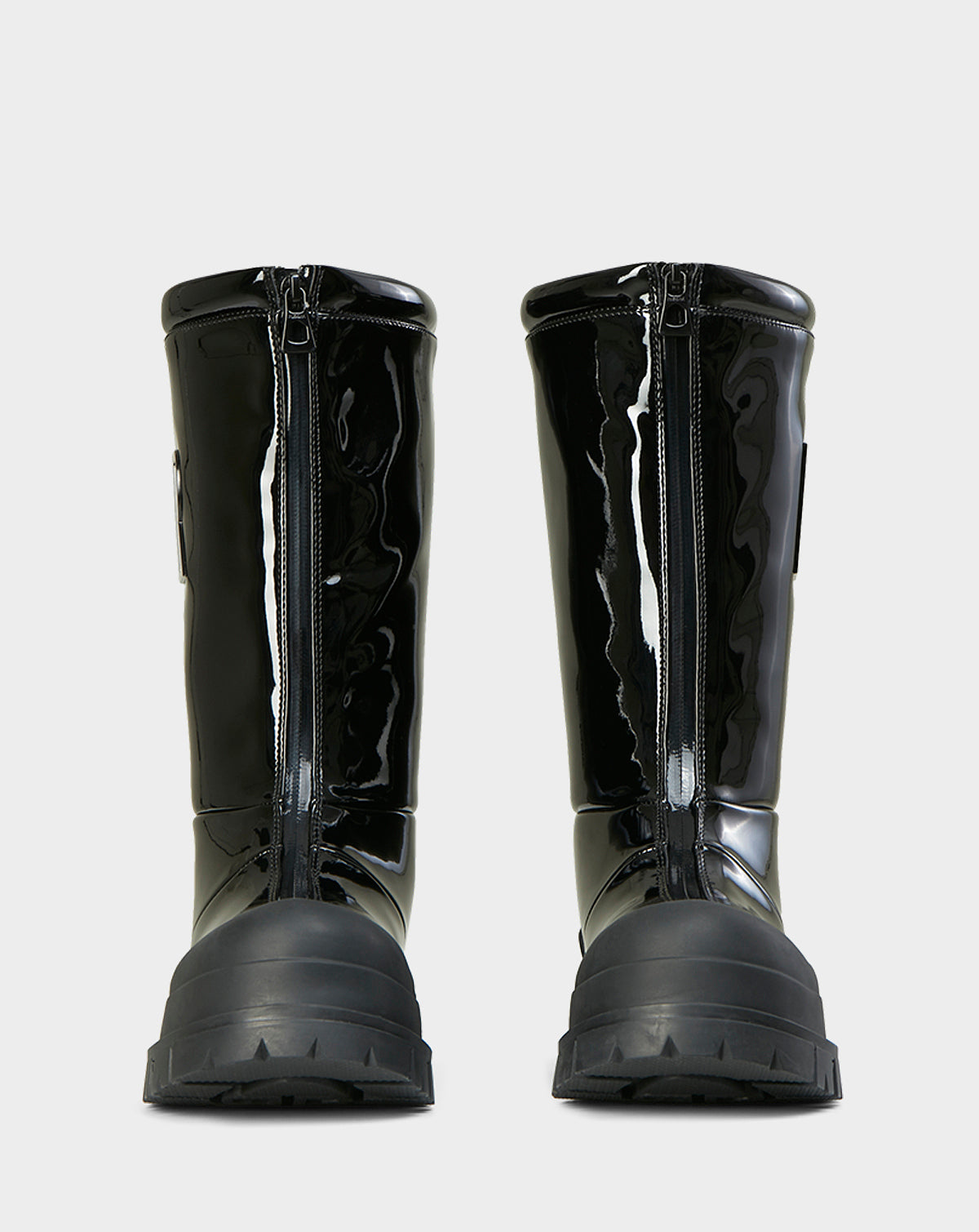 Front view of Rudsak KRISTAL HI - 8222510 BLACK boots in high-gloss black, featuring chunky grip soles and prominent front zippers, set against a plain light gray background.