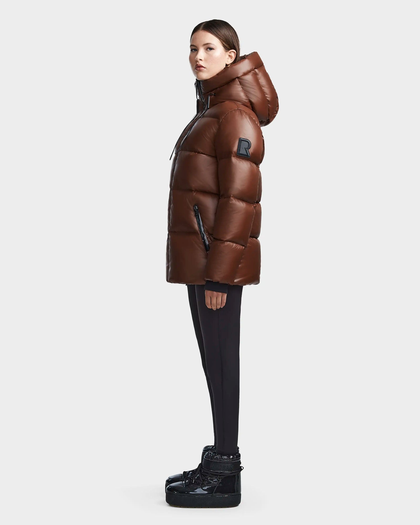 A woman in the Rudsak RITA S - L123527 Cohiba, a weather-resistant puffer coat.