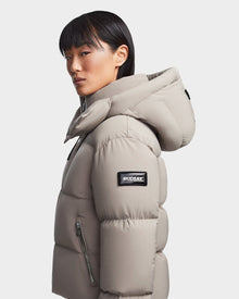 A woman in the Rudsak MAVE M - 8123572 Cement down puffer, enjoying the warmth of its lightweight insulation.
