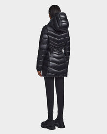 A person wearing the Rudsak MALAYA - L123510 Black women’s down puffer jacket stands with their back to the camera, paired with black pants and shoes, against a plain white background.