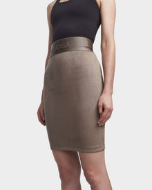 A person wears the CHEYNA - 8523514 Cement, a high-waisted taupe faux suede pencil skirt with an elasticized waistband by Rudsak, paired with a sleeveless black top against a plain white background.