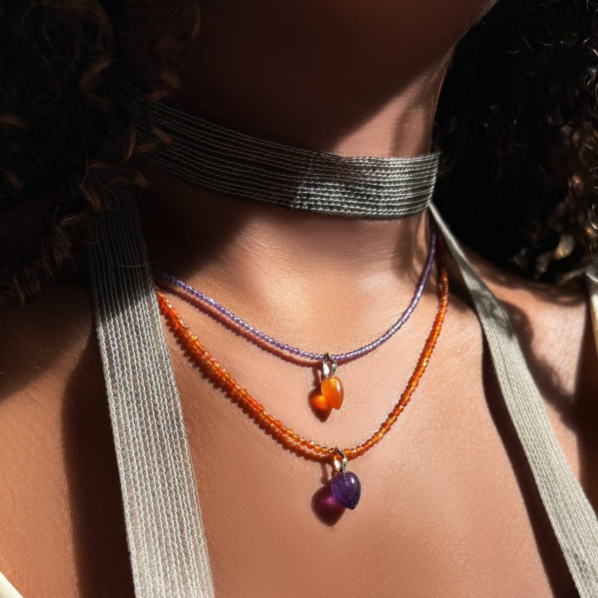 Amethyst Drop Charm with ripple bale styled on a carnelian slim gemstone, layered on a neck with a slim scarf.   