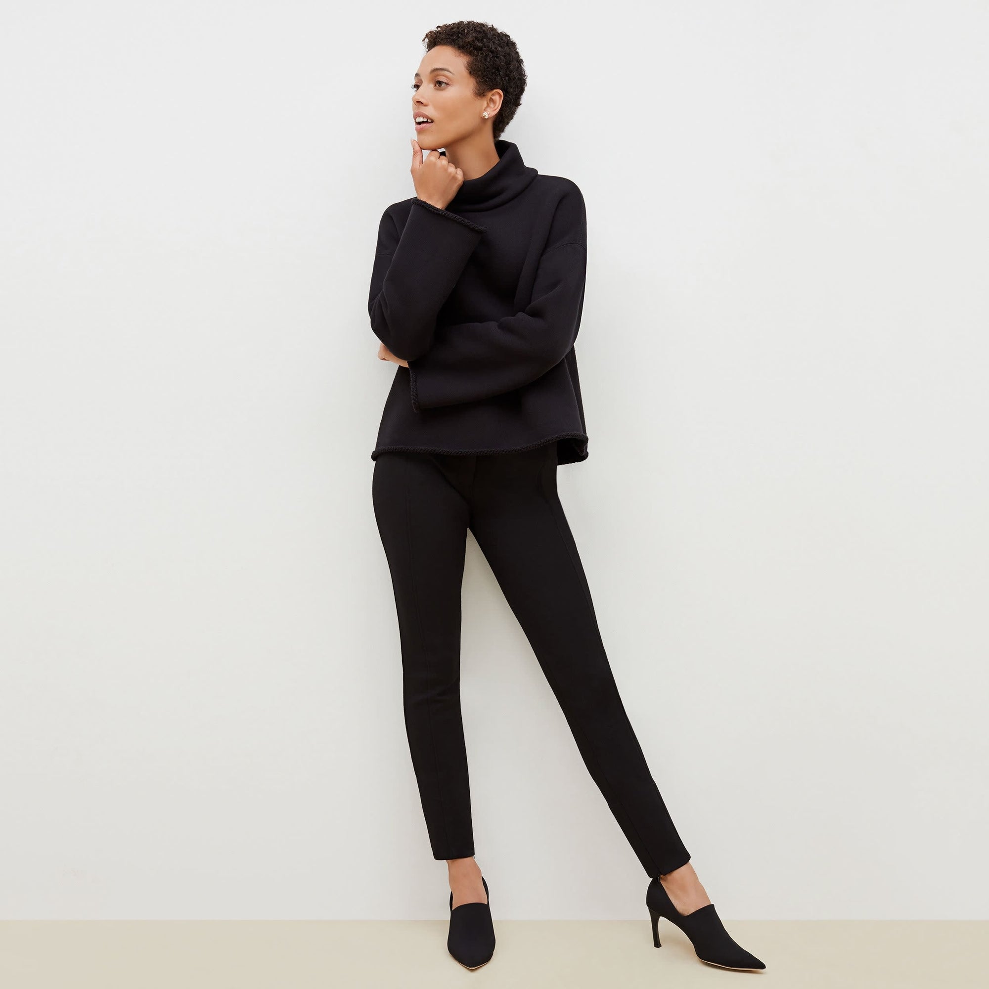 Front image of a woman standing wearing the Curie Pant--Worth in Black