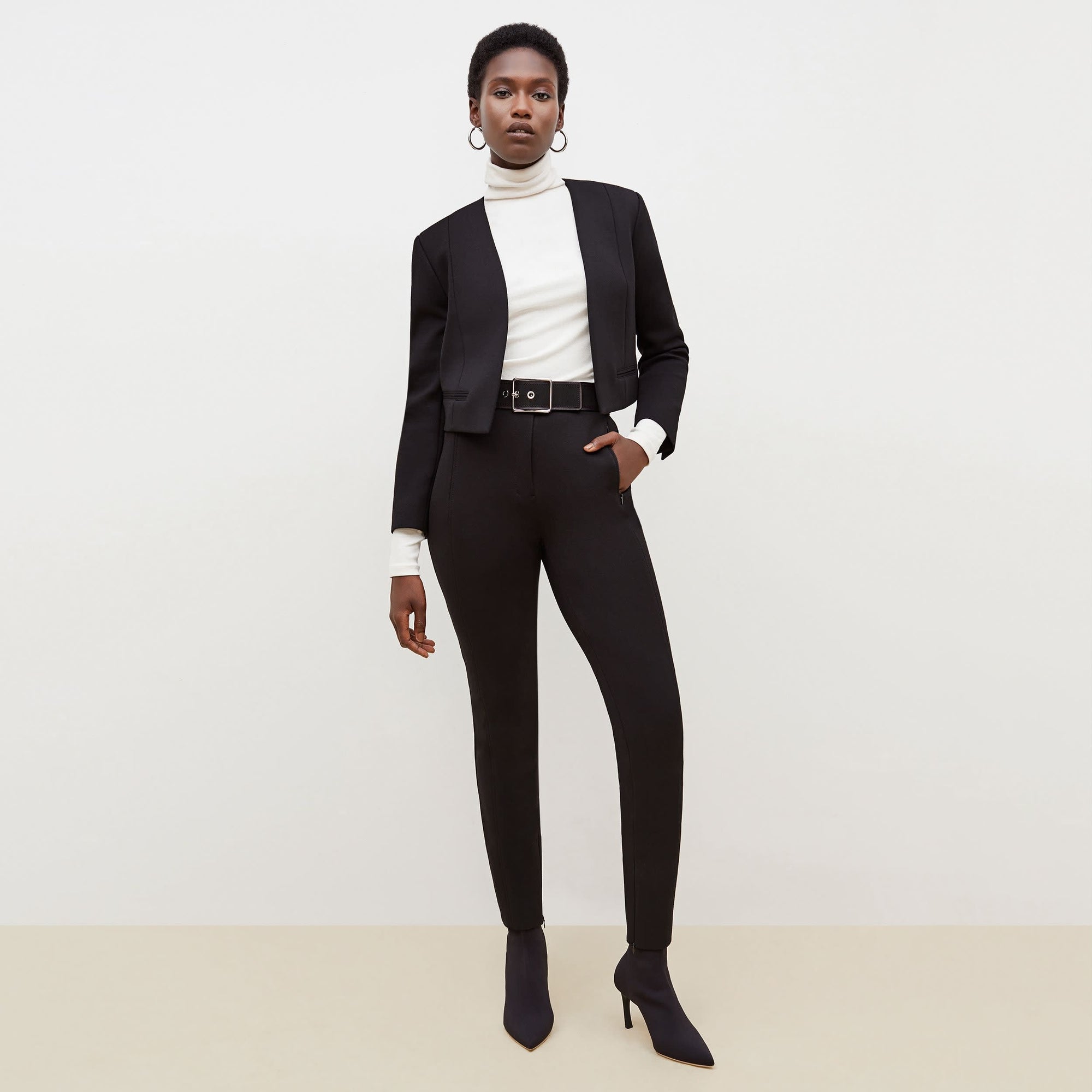 Front image of a woman standing wearing the Curie Pant--Worth in Black