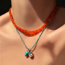 orange faceted opal necklace with natural turquoise slim gemstone necklace with chrysocolla drop charm and blue topaz molten knot charm on the neck.