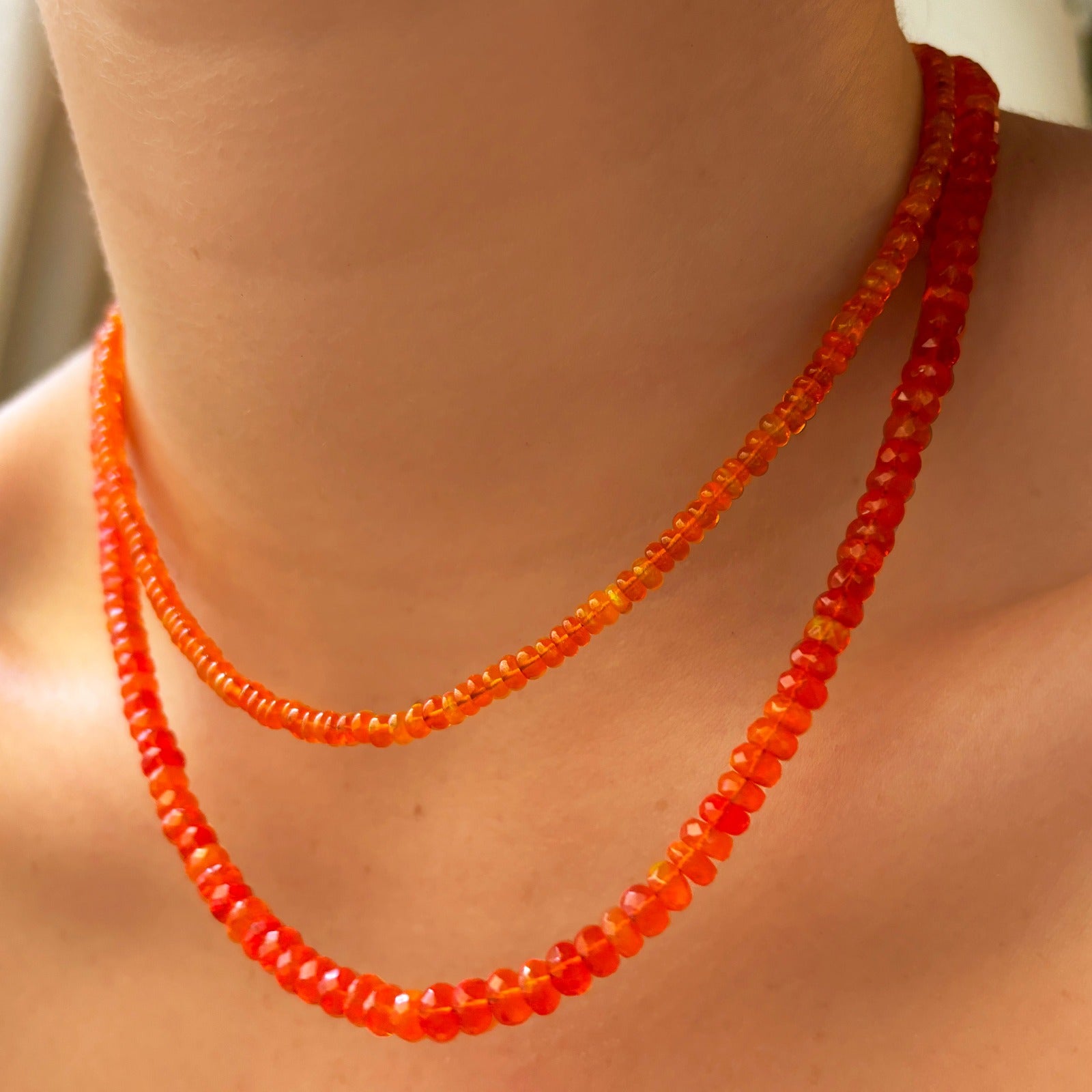 Shimmering beaded necklace made of smooth opal rondels in shades of orange on a slim gold lobster clasp. 