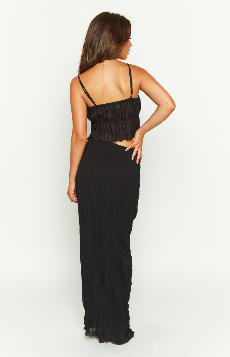 Back view of a black crinkled maxi skirt, showcasing its full length and flowy silhouette