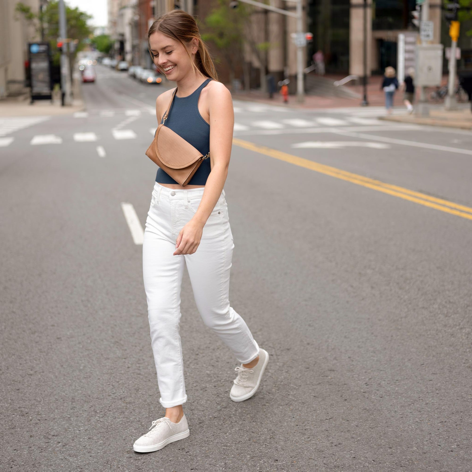 Nisolo Women's Go-To Eco-Knit Sneaker Linen image of woman wearing the shoe while crossing the street