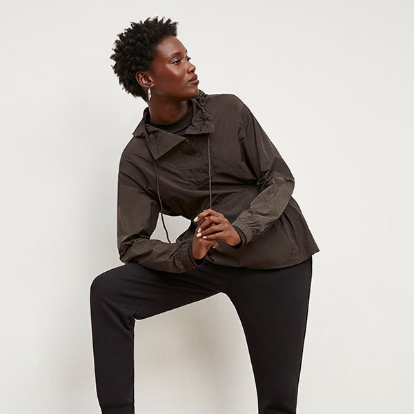 Front image of a woman standing wearing the Britt Hoodie—AirTech in Dark Moss | Exclude