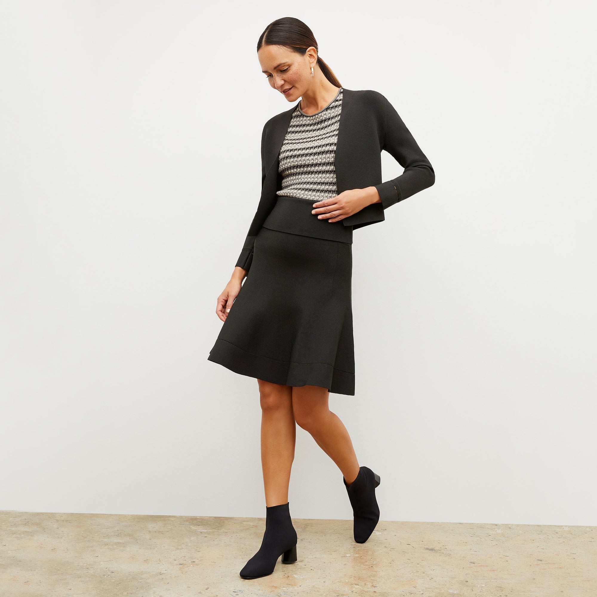 Front image of a woman standing wearing the Sant Ambroeus jardigan in black